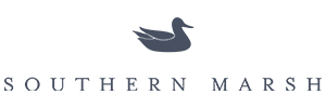 Southern Marsh logo: A graceful silhouette of a mallard duck in flight, set against a circular background with 'Southern Marsh' text. Known for its high-quality clothing and accessories, the brand effortlessly blends comfort and style, allowing individuals to connect with their surroundings while embodying classic elegance.