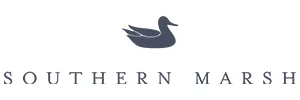 Southern Marsh logo: A graceful silhouette of a mallard duck in flight, set against a circular background with 'Southern Marsh' text. Known for its high-quality clothing and accessories, the brand effortlessly blends comfort and style, allowing individuals to connect with their surroundings while embodying classic elegance.