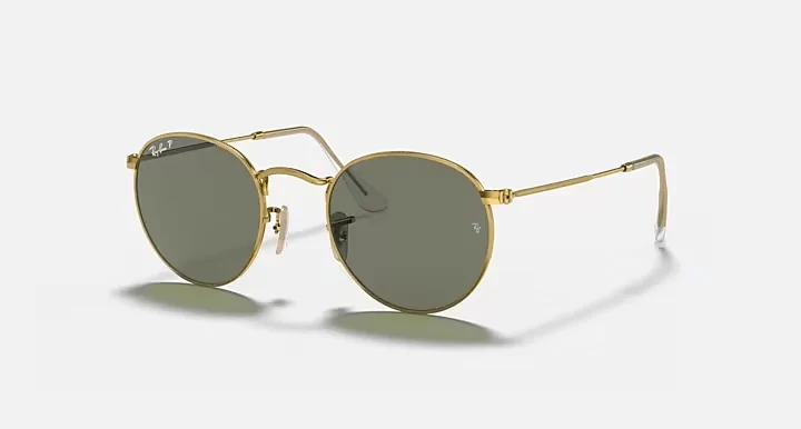 Gold-framed Ray-Ban Round Metal sunglasses with green G-15 lenses, adding a retro flair to your sunny day adventures.