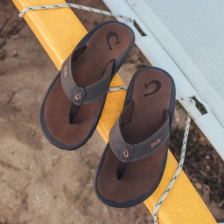 Pair of OluKai brown leather sandals designed for comfort and durability in 30A.