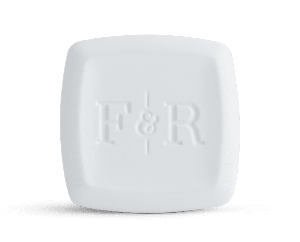 A clean and minimalist white solid cologne bar embossed with the Fulton & Roark logo, ideal for freshening up after exploring the vibrant boardwalks of Fort Walton Beach or the scenic trails of Miramar.
