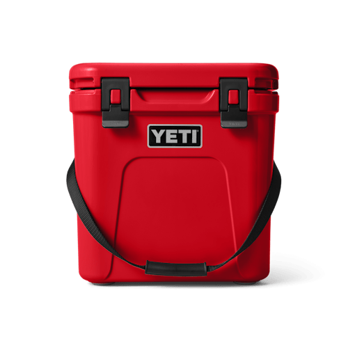 Compact, vibrant red YETI Roadie 24 cooler with a durable strap, perfect for keeping beverages cool at Panama City Beach's sandy shores.