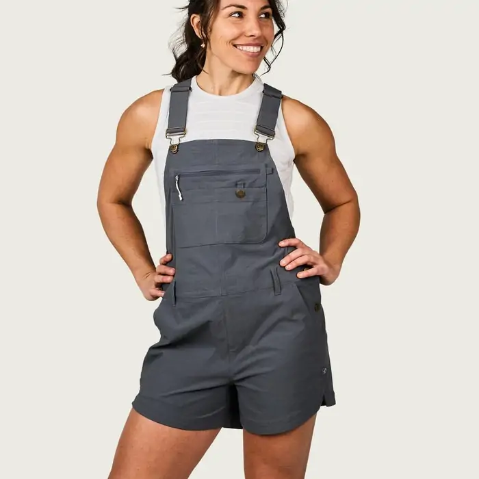A woman in gray overalls by Marsh Wear, featuring functional pockets and adjustable straps, ideal for a casual outing in Panama City Beach or exploring local shops in Destin.